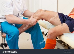 doctor inspecting athlete's knee