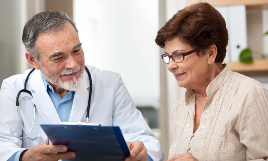 doctor reviewing chart with elderly patient