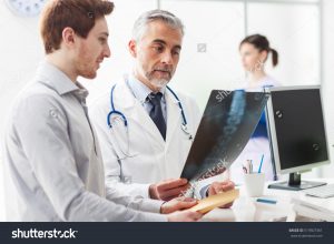 stock-photo-doctor-in-the-office-examining-an-x-ray-and-discussing-with-a-patient
