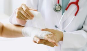 doctor bandaging wrist after stitching wound